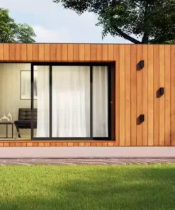 “Contemporary tiny modular home with wood-panel exterior and large windows, set in a green landscape under blue skies.”